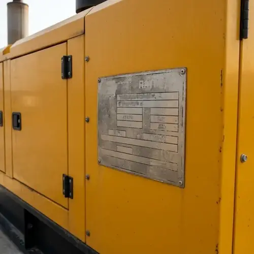 diesel-genset-enclosure-nameplate-rating-fields Diesel generator set nameplate on the enclosure side showing indistinct standby, prime, and continuous rating fields on a concrete pad, a physical generator prime vs standby rating verification point.